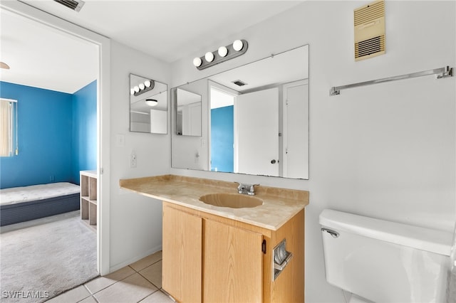 bathroom featuring tile patterned flooring, vanity, and toilet