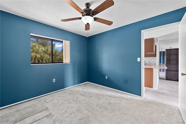 carpeted spare room with ceiling fan and sink