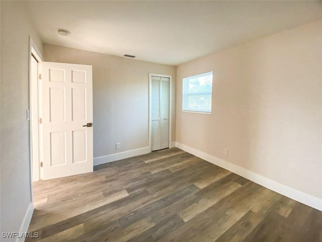 unfurnished bedroom featuring hardwood / wood-style floors and a closet