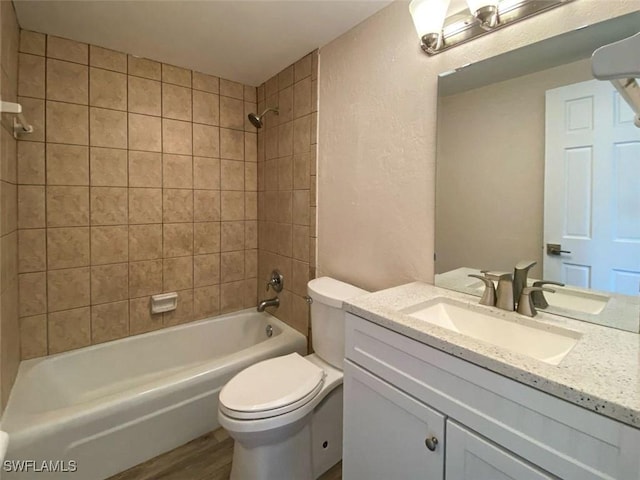 full bathroom with toilet, vanity, tiled shower / bath combo, and hardwood / wood-style flooring