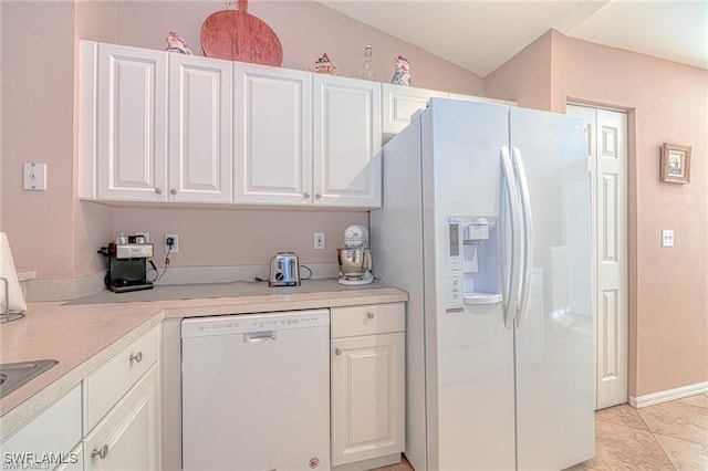 kitchen featuring white cabinetry, white appliances, light tile patterned floors, and vaulted ceiling