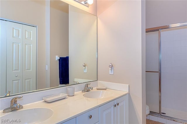 bathroom featuring vanity, toilet, and a shower with shower door