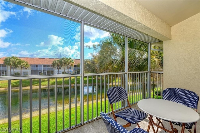 sunroom featuring a water view