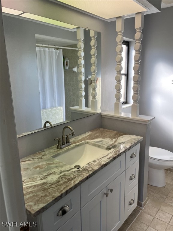 bathroom featuring a shower with shower curtain, vanity, and toilet