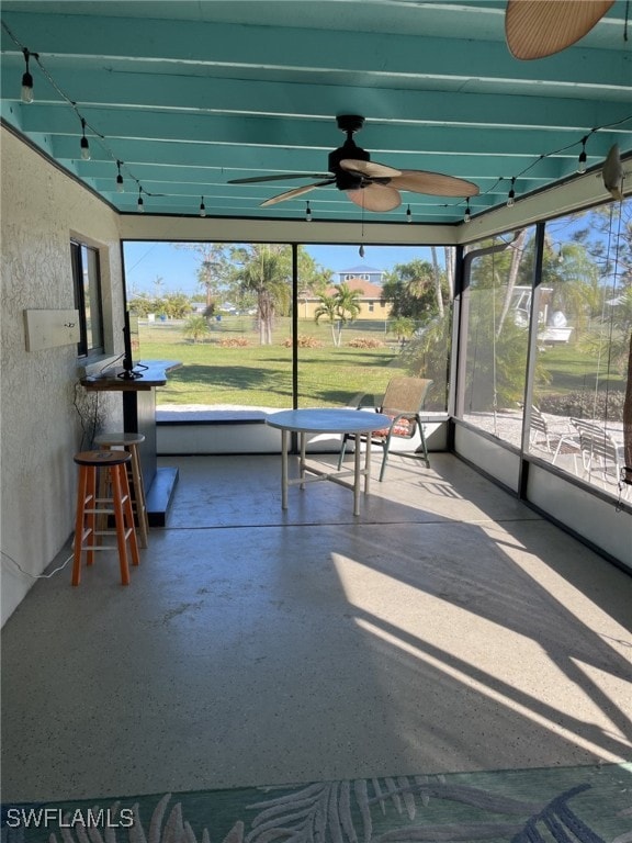 unfurnished sunroom featuring ceiling fan