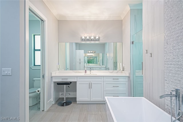 bathroom with crown molding, a bathtub, vanity, and toilet