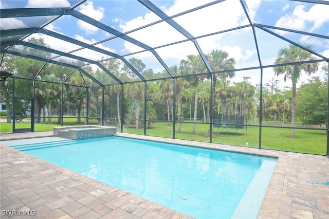 view of pool featuring an in ground hot tub, a patio, glass enclosure, and a lawn