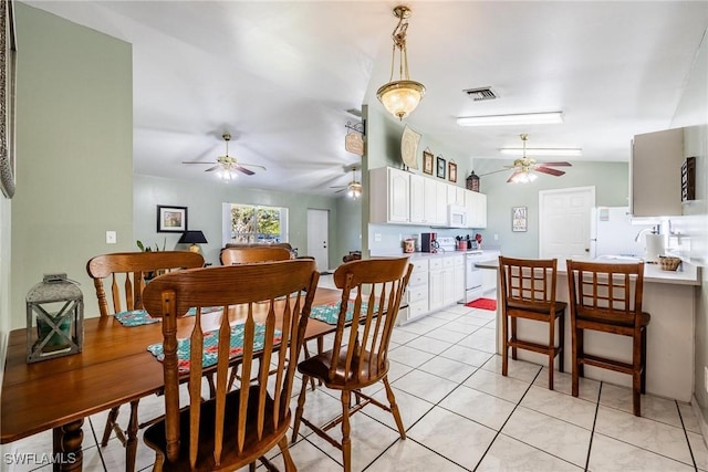 tiled dining room with lofted ceiling