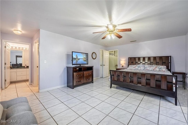 bedroom with ceiling fan, light tile patterned floors, and ensuite bathroom