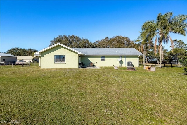 rear view of property with a yard and cooling unit