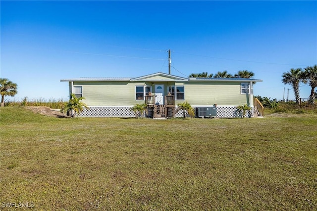 manufactured / mobile home featuring a front lawn and central AC unit