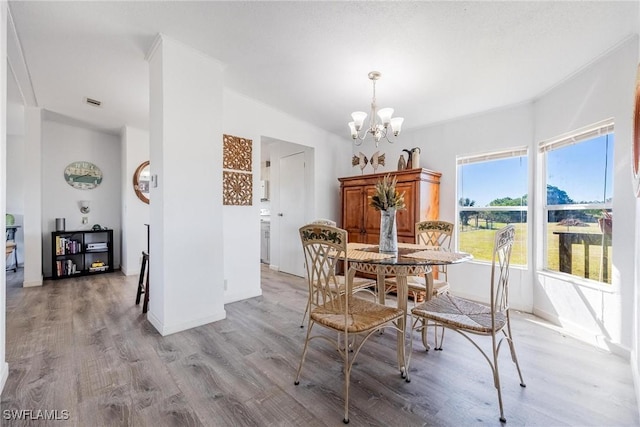 dining space with a chandelier and light hardwood / wood-style flooring