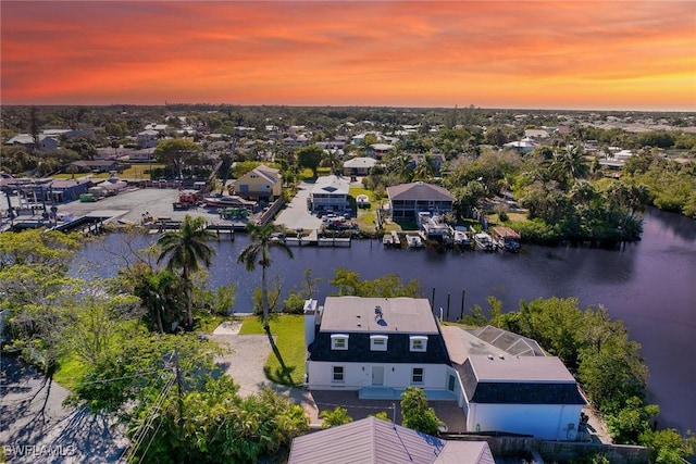 aerial view at dusk featuring a water view