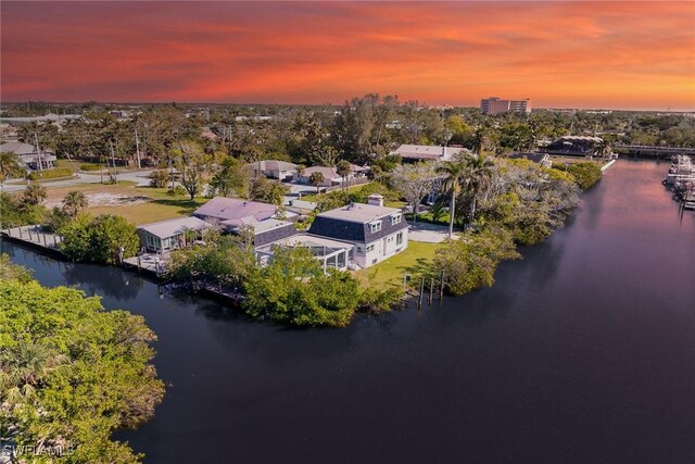 aerial view at dusk featuring a water view