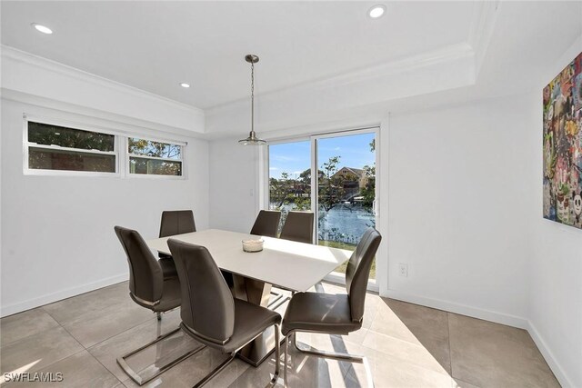 dining room with light tile patterned floors, a water view, and crown molding