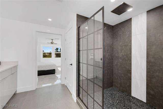 bathroom featuring tile patterned flooring, a tile shower, and ceiling fan