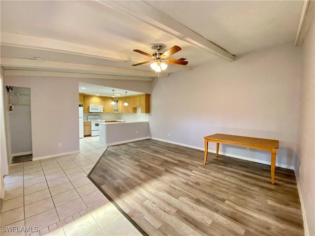 unfurnished living room with beamed ceiling, light tile patterned floors, a textured ceiling, and ceiling fan