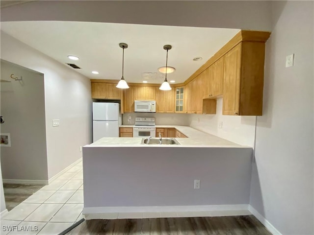 kitchen featuring kitchen peninsula, sink, light hardwood / wood-style floors, and white appliances