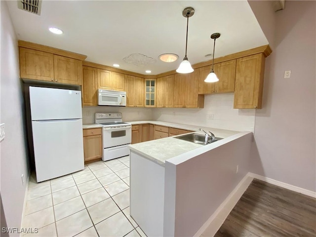 kitchen featuring kitchen peninsula, sink, light tile patterned floors, and white appliances