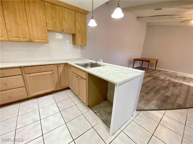 kitchen featuring pendant lighting, sink, light hardwood / wood-style flooring, ceiling fan, and kitchen peninsula