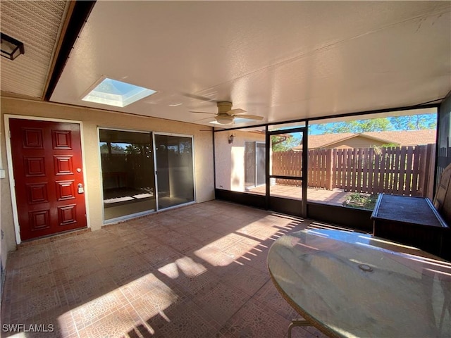 unfurnished sunroom with a skylight and ceiling fan