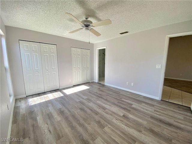 unfurnished bedroom featuring a textured ceiling, light hardwood / wood-style flooring, and ceiling fan