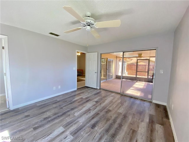 spare room featuring ceiling fan, wood-type flooring, and a textured ceiling