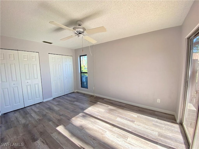 unfurnished bedroom featuring hardwood / wood-style flooring, ceiling fan, and a textured ceiling