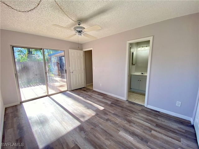 unfurnished bedroom featuring access to outside, ensuite bathroom, hardwood / wood-style flooring, ceiling fan, and a textured ceiling