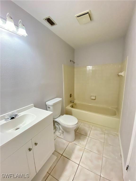 full bathroom with tile patterned floors, vanity, toilet, and washtub / shower combination