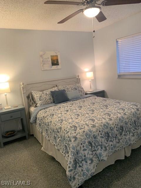 bedroom featuring ceiling fan, carpet floors, and a textured ceiling