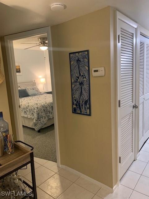 bedroom featuring light tile patterned floors, a closet, and ceiling fan