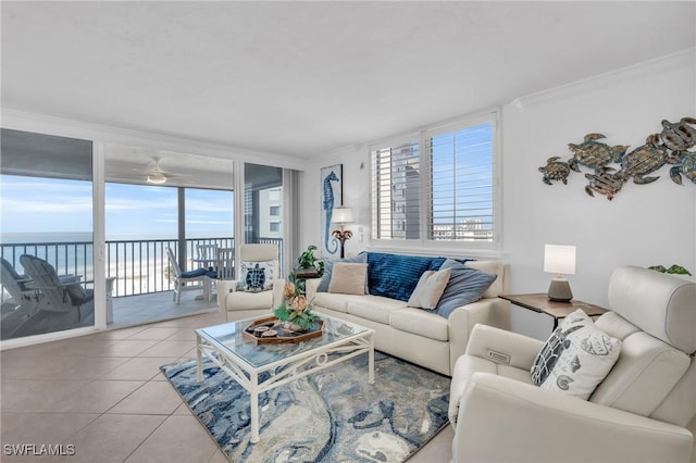 living area featuring a water view, light tile patterned floors, a ceiling fan, and crown molding