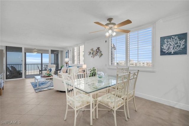 dining area with a healthy amount of sunlight, light tile patterned floors, ceiling fan, and baseboards