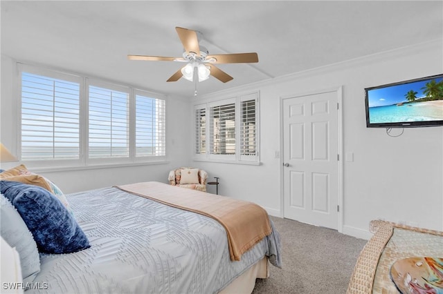 carpeted bedroom featuring a ceiling fan, baseboards, and crown molding