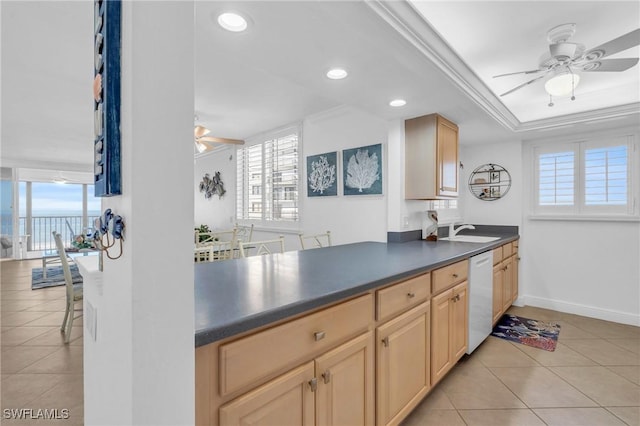 kitchen with dishwasher, light brown cabinetry, dark countertops, and a healthy amount of sunlight