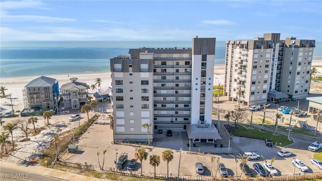 drone / aerial view featuring a beach view and a water view