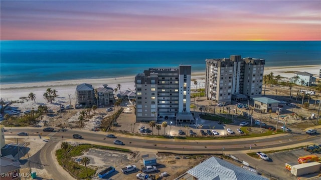 birds eye view of property featuring a view of city, a water view, and a beach view