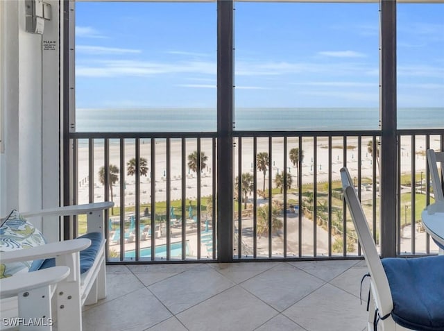 balcony with a water view and a view of the beach