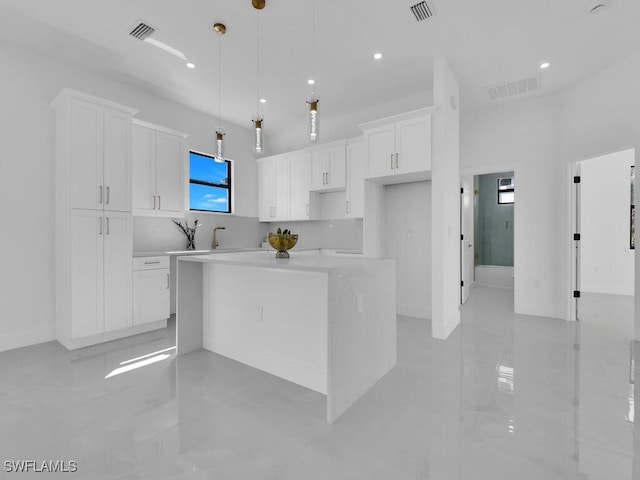 kitchen with white cabinets, a center island, and hanging light fixtures