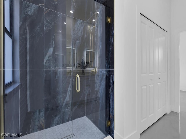 bathroom with a shower with door and tile patterned flooring