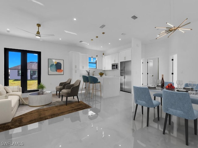 living room featuring ceiling fan with notable chandelier