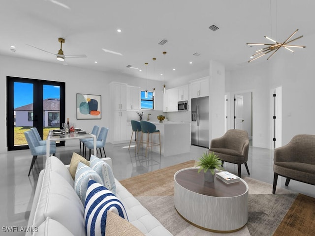 living room with ceiling fan with notable chandelier and french doors