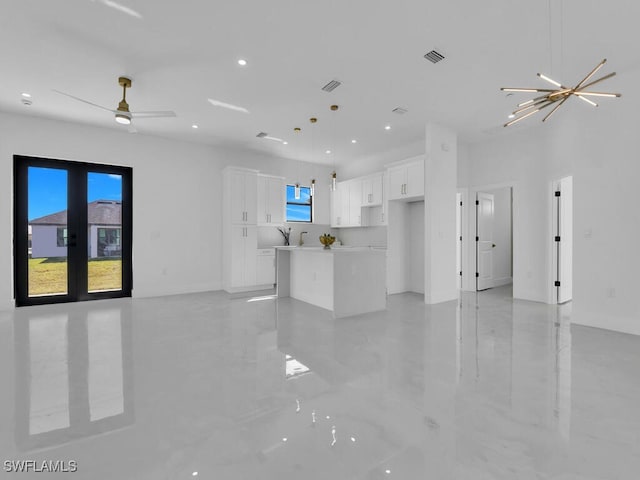 unfurnished living room with french doors and an inviting chandelier