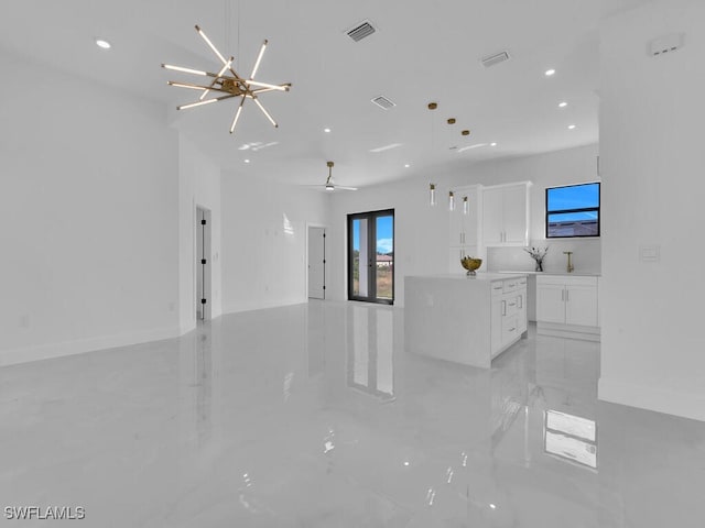 unfurnished living room with ceiling fan with notable chandelier