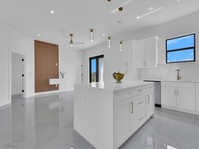 kitchen with a kitchen island, sink, white cabinets, hanging light fixtures, and stainless steel dishwasher