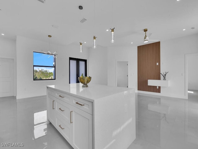 kitchen featuring white cabinetry, pendant lighting, ceiling fan, and a kitchen island