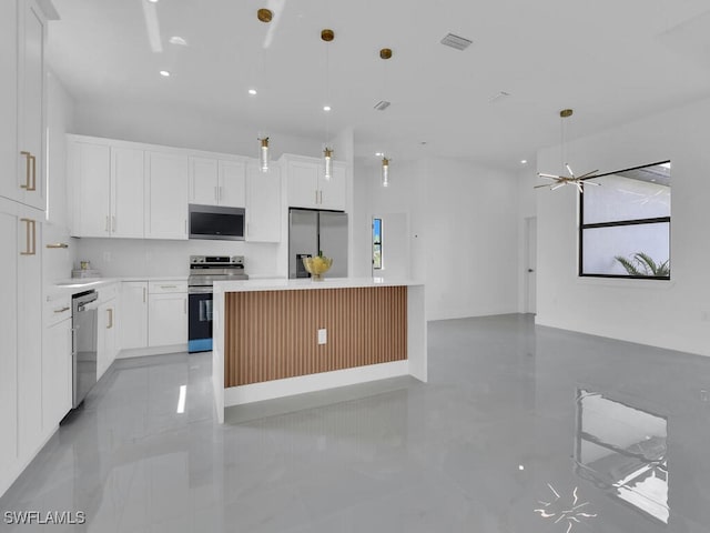 kitchen featuring hanging light fixtures, appliances with stainless steel finishes, a center island, and white cabinets