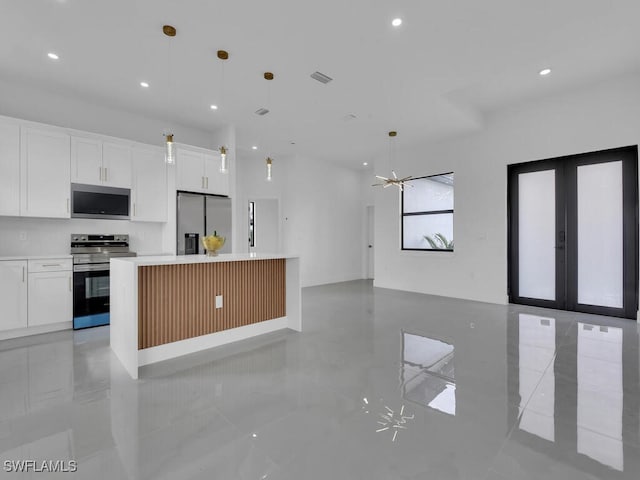 kitchen with white cabinetry, appliances with stainless steel finishes, a center island, and decorative light fixtures