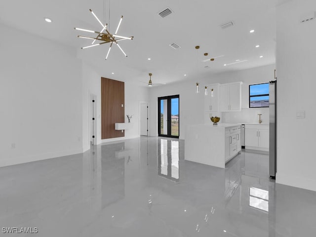 unfurnished living room with french doors and a notable chandelier